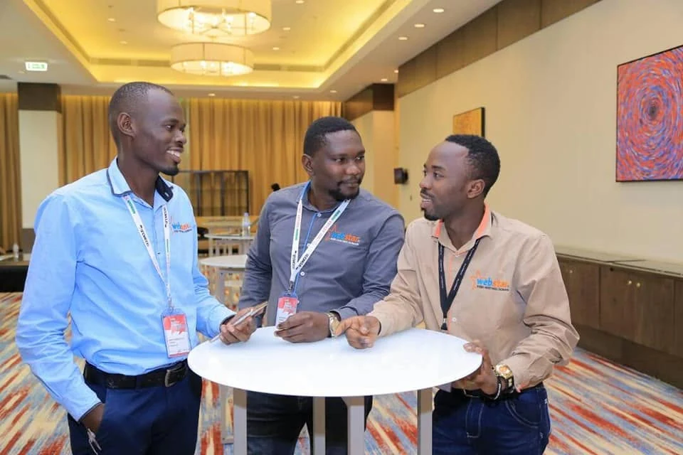 Webstar team members in conversation at a Kigali event.